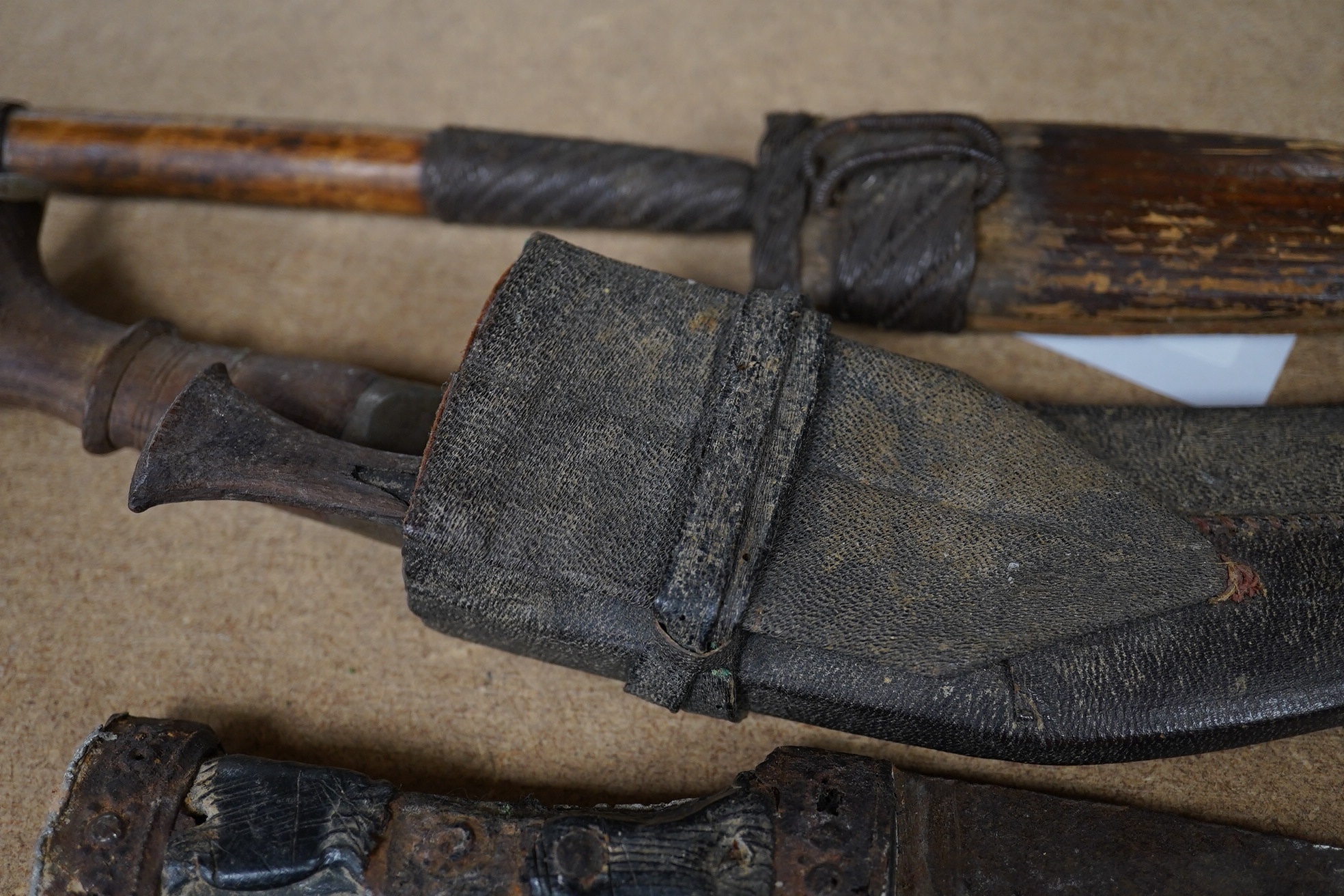 Three daggers, two with sheaths and a kukri knife, largest 33cm in length. Condition - poor